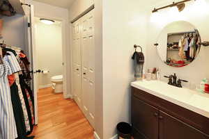 Bathroom featuring hardwood / wood-style floors, vanity, and toilet