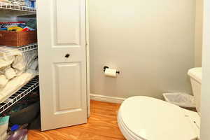 Bathroom with hardwood / wood-style flooring and toilet