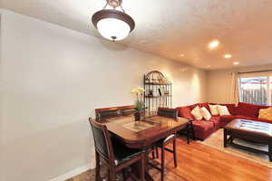 Dining area with a textured ceiling and hardwood / wood-style flooring