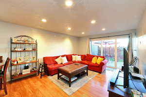 Living room with light wood-type flooring and a textured ceiling