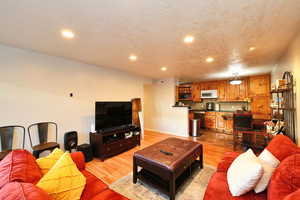 Living room with light hardwood / wood-style flooring and a textured ceiling