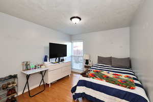 Bedroom featuring light wood-type flooring and a textured ceiling