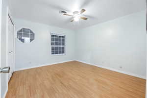 Empty room with ceiling fan and light hardwood / wood-style flooring