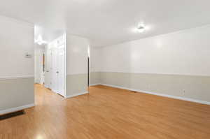 Empty room with light wood-type flooring and crown molding