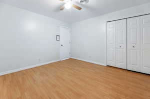 Unfurnished bedroom featuring ceiling fan, a closet, and light hardwood / wood-style floors