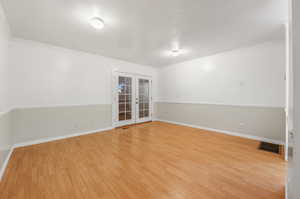 Empty room featuring ornamental molding, light hardwood / wood-style flooring, and french doors