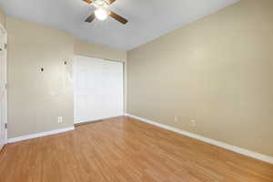 Unfurnished bedroom with light hardwood / wood-style flooring, a closet, and ceiling fan