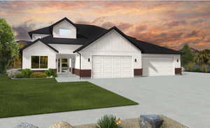 View of front of home with a yard and a garage