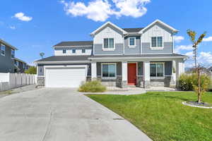 View of front of property featuring a porch, a garage, and a front yard