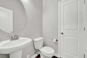 1/2 Bathroom with sink, toilet and storage closet