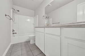 Full bathroom featuring shower / bathing tub combination, vanity, toilet, and tile patterned floors