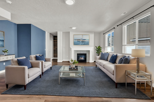 Living room featuring a tile fireplace and hardwood / wood-style LVP floors. Virtually Staged