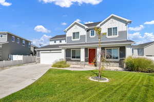 View of front of house featuring a front yard, a garage, and a porch