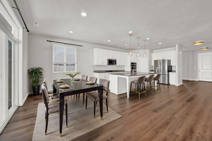 Dining room featuring dark hardwood / wood-style LVP floors and sink. Virtually Staged