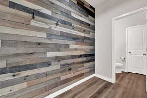 Interior space featuring dark hardwood / wood-style LVP flooring and a accent wall