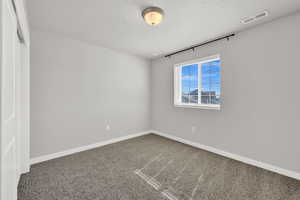 Spare room with a textured ceiling and carpet flooring