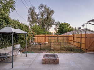 Patio terrace at dusk featuring an outdoor fire pit