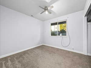 Spare room featuring ceiling fan and carpet