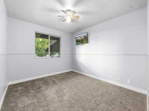 Carpeted empty room with ceiling fan