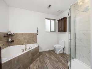 Bathroom featuring shower with separate bathtub, hardwood / wood-style floors, and toilet