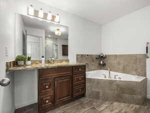 Bathroom featuring shower with separate bathtub, hardwood / wood-style floors, and vanity