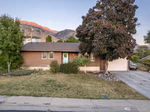 View of front of house with a mountain view and a front yard