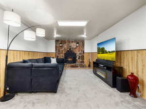 Carpeted living room featuring a textured ceiling and a wood stove