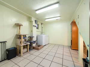 Washroom featuring washer and clothes dryer and light tile patterned flooring