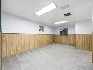 Empty room featuring wooden walls and light colored carpet