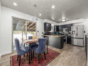 Dining area featuring a textured ceiling and light wood-type flooring