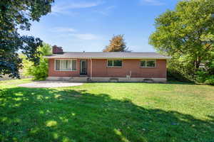 View of front of property featuring a front lawn and a patio