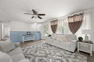 Living room with ceiling fan and hardwood / wood-style floors