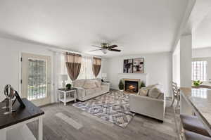 Living room with light hardwood / wood-style floors and ceiling fan