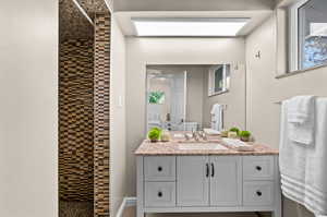 Bathroom with walk in shower, vanity, and a wealth of natural light