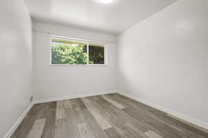 Empty room with light hardwood / wood-style floors