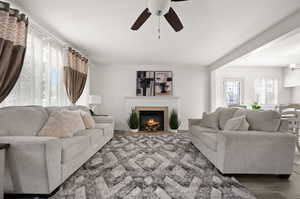 Living room featuring wood-type flooring, ceiling fan, and a tile fireplace