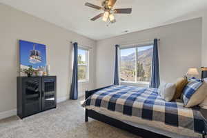 Carpeted bedroom featuring a mountain view and ceiling fan