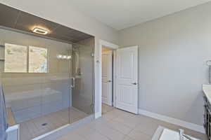 Bathroom featuring vanity, a shower with door, and tile patterned floors