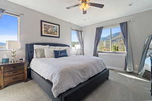 Carpeted bedroom with ceiling fan and a mountain view