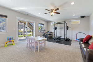 Workout area with ceiling fan and carpet