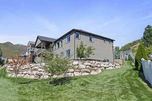 View of property exterior featuring a mountain view and a yard