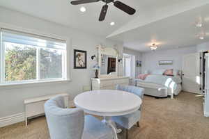 Carpeted bedroom featuring vaulted ceiling and ceiling fan