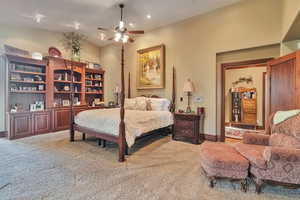 Carpeted bedroom with ceiling fan and vaulted ceiling