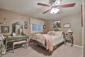 Carpeted bedroom featuring ceiling fan