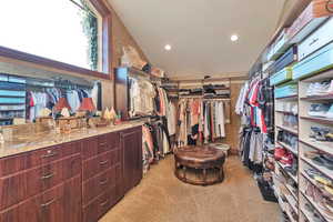 Walk in closet featuring light colored carpet