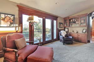 Sitting room with vaulted ceiling and light colored carpet