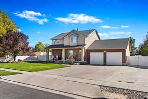 View of front of property featuring a garage and a front lawn