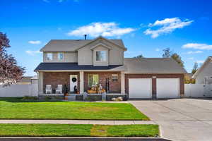 View of front property with a front lawn, a porch, and a garage