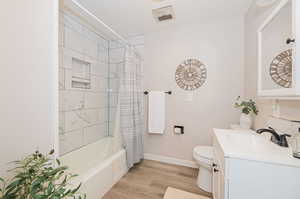 Full bathroom with shower / bath combo, toilet, vanity, and hardwood / wood-style floors