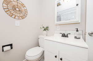 Bathroom with a shower with curtain, vanity, and toilet